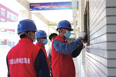 石嘴山市惠农区供电公司配电运维人员进驻石嘴山市第一中学考点，义务巡检电气设备。　　　　　安小霞  韩霜   摄影报道