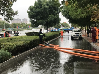 宁安南大街非机动车道积水，工作人员正在抽排。&&