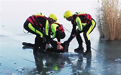 男子被救援人员拉上冰面。　消防供图