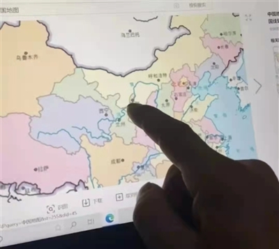 李某在地图上用手指着家乡的位置。警方供图