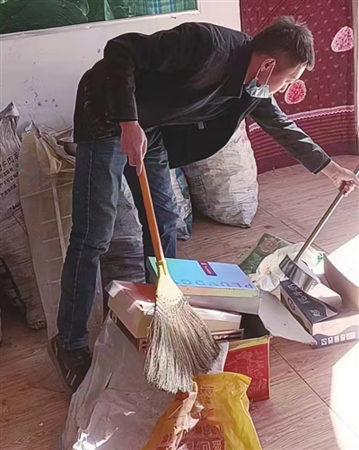孙启龙帮助村民打扫卫生。受访者供图