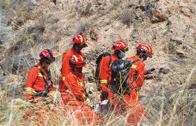 消防救援人员将受伤男子抬下山。陈健 刘坤　摄影报道