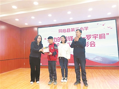 同心县三小召开表彰大会对罗宇桐进行表彰，失主李花（右二）也来到现场。图片由同心县委宣传部提供