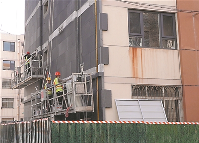 4月10日，在银川市兴庆区凤凰北街宁静园老旧小区建筑节能改造工地，工人们正在为楼体外墙粘贴保温板。这种新型保温板既保温又防火，夏季可减少热量进入室内，达到节能减排效果。今年，兴庆区实施老旧小区建筑节能改造项目8个，项目建筑面积约78万平方米，惠及9209户居民。本报记者  高晓刚  摄
