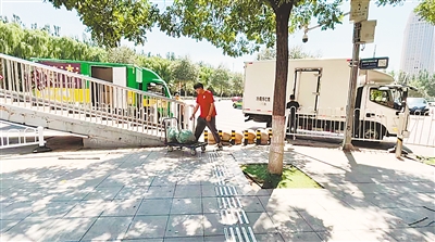 银川市金凤万达广场过街天桥附近的入口被石礅和铁桩围住。