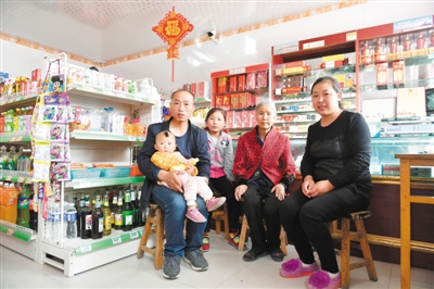 <p>　　庞凤英（右二）一家在自家商店拍摄全家福。</p>