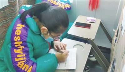     小学生杨斐在D4350次列车上写作业。