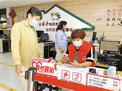 8月31日，社区工作人员帮助老年居民在手机上办理业务。      本报记者 毛雪皎 摄
