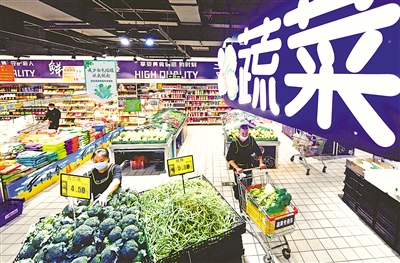 10月4日，新百連超銀川興慶府店,，工作人員正在上架蔬菜,。 本報(bào)記者 王曉龍 攝