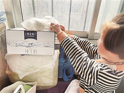 穆女士的孙女帮奶奶解开塑料袋。       本报记者   安小霞   摄