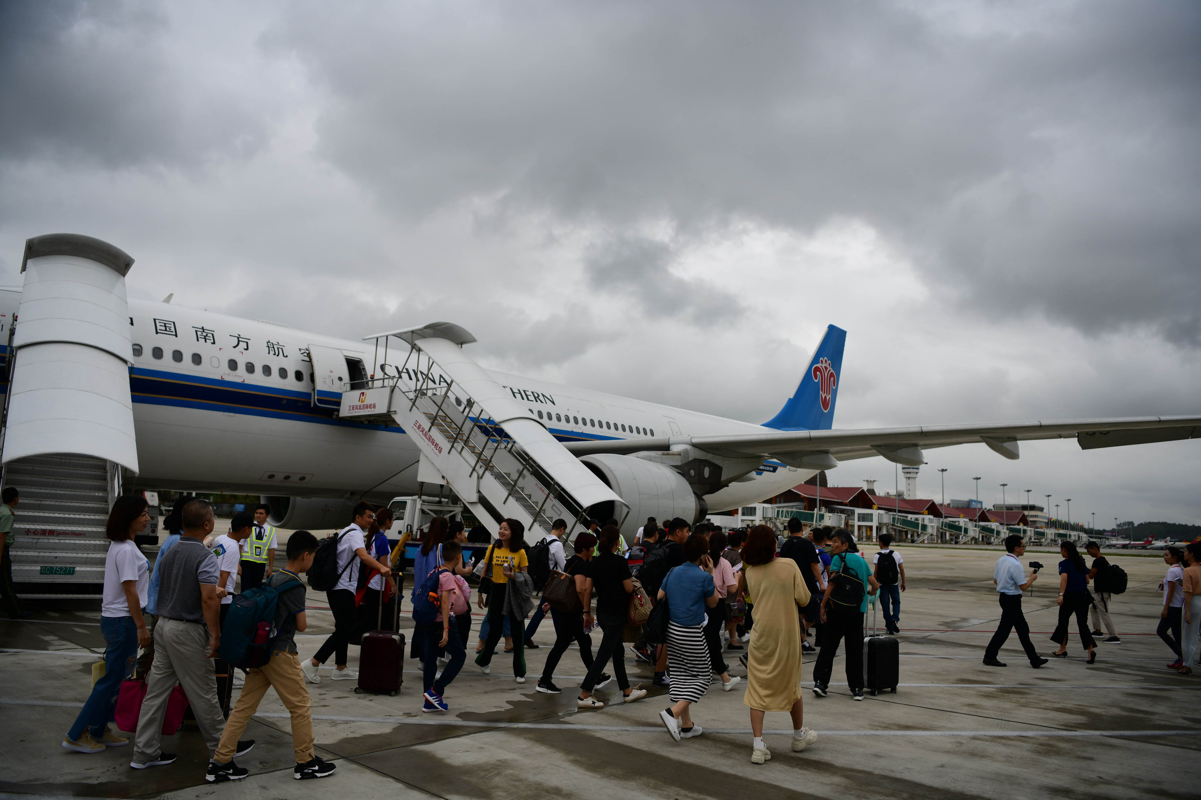 在海南三亚凤凰国际机场,乘坐首班三亚至伦敦直飞航班的旅客准备登机