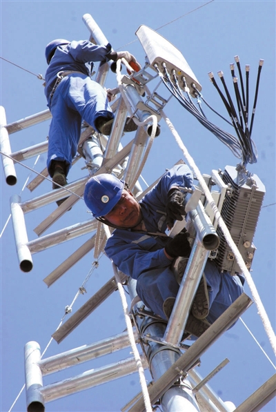 2009年3月10日，在银川市兴庆区一小区楼顶，中国移动宁夏公司的工作人员正在架设3G网络。