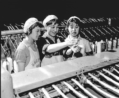     银川棉纺厂粗纱车间老工人帮助新工人提高技术水平。

    米寿世摄于1972年5月