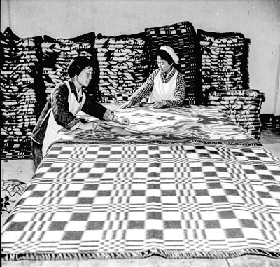     银川毛纺厂工人在认真检查毛毯质量。朱康洛摄于1963年