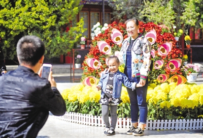 <p>　　10月3日，银川中山公园，游人在花坛前拍照留念。　　　　　　　　　　　　本报记者　王猛　实习生　马楠　摄</p>