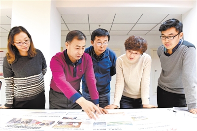 <p>　　11月8日晚上10时，宁夏日报社总编室的夜班编辑们在讨论报纸版面的编排。</p>