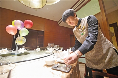 <p>　　在银川一家酒店，　服务员苏金霞正在摆放餐具，为客人的团圆宴做准备。</p>
