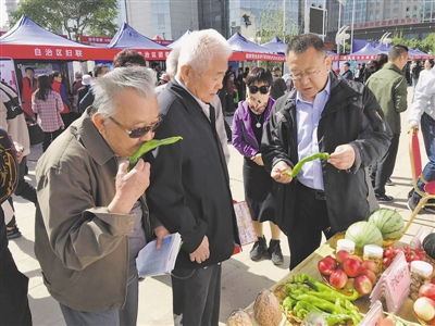 <p>　　宁夏农科院工作人员向群众展示农产品新品种。　本报记者　姜璐　摄</p>
