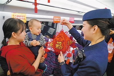 <p>　　列车乘务员向小乘客送礼物。</p>