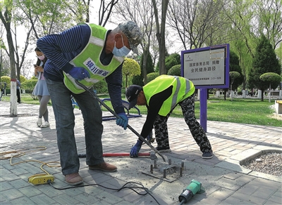 5月5日，在银川市兴庆区北京东路，市政部门施工人员在清理人行道上的废弃基座、铁钉、坑洞等障碍物。这些障碍物是垃圾桶、标志牌拆除迁移后留下的，对行人安全造成隐患，清除后道路更加平整，市民出行也更安全。　　　　　　　　本报记者   高晓刚   摄