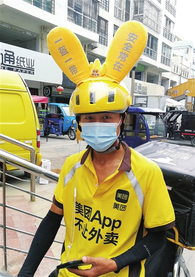一位头戴“袋鼠耳朵”的美团外卖员在送餐途中。　本报记者  高晓刚   摄