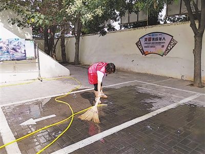<p>　　银川市金凤区长城中路街道办事处紫园社区工作人员用水清洗路面。</p>