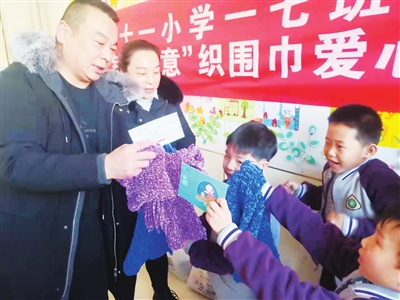     银川二十一小参与学生将织好的围巾交给老师。　　本报记者   闵良   摄