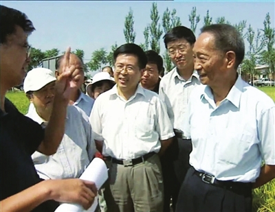 2002年8月，袁隆平（右一）在灵武田间考察。《宁夏新闻联播》视频截图