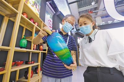 <p>在重庆主题馆，中国工艺美术大师蔡泽荣（左）向观展者讲述漆器制作技巧。</p>