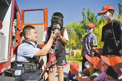 <p>　　民警给孩子们展示警用设备。</p>