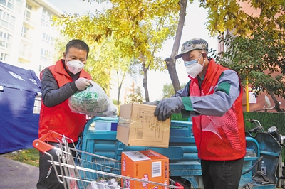 <p>　　在银川市兴庆区云和家园，社区志愿者王双丁（左）与陈万开为隔离人员搬送生活用品。</p>