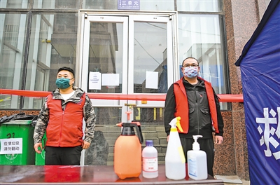 <p>青年党员志愿者李兵（左）、马涛坚守在银川市塞北嘉苑小区封控管理的单元门前。</p>