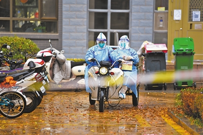 <p>　　迎着寒风，冒着大雨，承担核酸检测任务的医护人员驾驶电动三轮车前往下一个采集点。本报记者　王鼎　摄　</p>