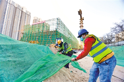 <p>　　银川一建筑工地内，工人用绿网覆盖堆放的物料裸土砂石，以防止扬尘。</p>