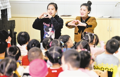 <p>李华芳（右）给孩子教音乐手指舞。重回幼师岗位，李华芳上手很快。</p>