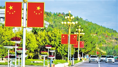 9月29日，固原市街头，一面面国旗在草木和鲜花的映衬下，更加鲜艳夺目。
