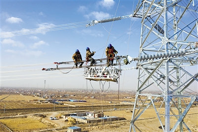 12月12日，电力工人在吴忠境内对典农220千伏输变电工程跨越包兰铁路架线作业开展间隔棒安装工作。据了解，典农220千伏输变电工程总投资6.05亿元，预计2023年年底投运，由宁夏首座全户内220千伏变电站——典农220千伏变电站，以及总长73.9公里输电线路组成，建成后可为银川经济技术开发区一批新型产业提供电力保障。                                                  本报通讯员 田满潮 摄