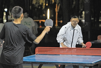     ④ 夜幕下，在中卫体育馆周边的运动健身场所，乒乓球是青少年热衷的运动项目。