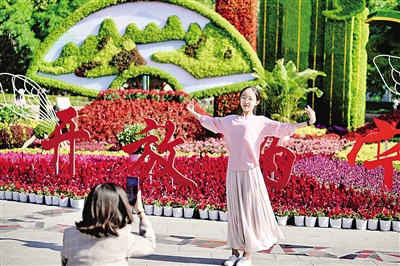     国庆节期间，银川市光明广场上，姹紫嫣红花香四溢，一位少女在花坛前起舞。		 					     本报记者　马楠　摄