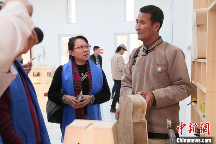 图为乌力吉(右)为来访嘉宾介绍马头琴。受访者供图