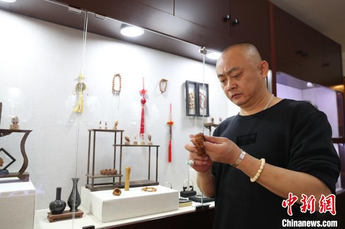 宁夏核雕艺人李文斌正在展示他雕刻好的作品。　于晶 摄