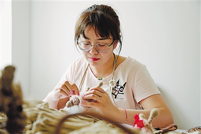 <p>　　①吴琼在制作非遗麻编产品。本报记者　马照刚　摄</p>