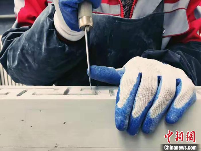 图为临夏砖雕艺人创作时手部特写。(资料图) 徐克荣 摄