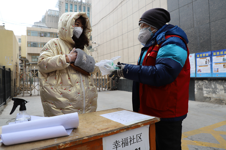 幸福社区副主任段军洁给值守在散居楼疫情检测点的王婕送来了暖宝宝。.JPG