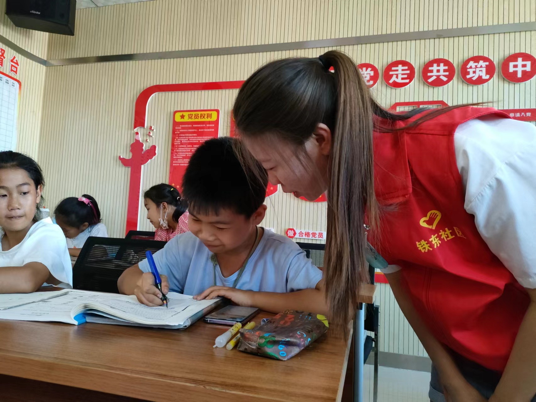 “守望”志愿者服务对在铁东社区志愿者辅导孩子们完成作业.jpg