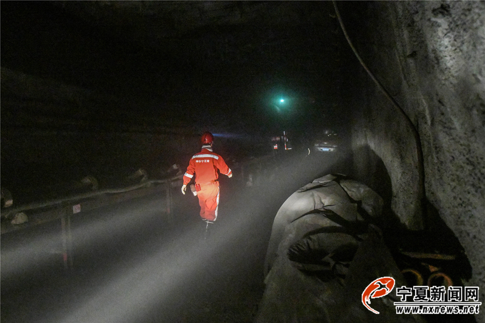 巷道昏暗、潮湿。沿路可以看到加固巷道的钢材、源源不断向巷道输送着新鲜空气的粗大通风管、载着矿渣的皮带运输机、堆放整齐的施工器材等。