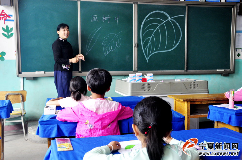 刘秋蓉正在给丁塘镇中心小学的学生上美术课。她讲课语言生动、形象，因此很受学生欢迎。
