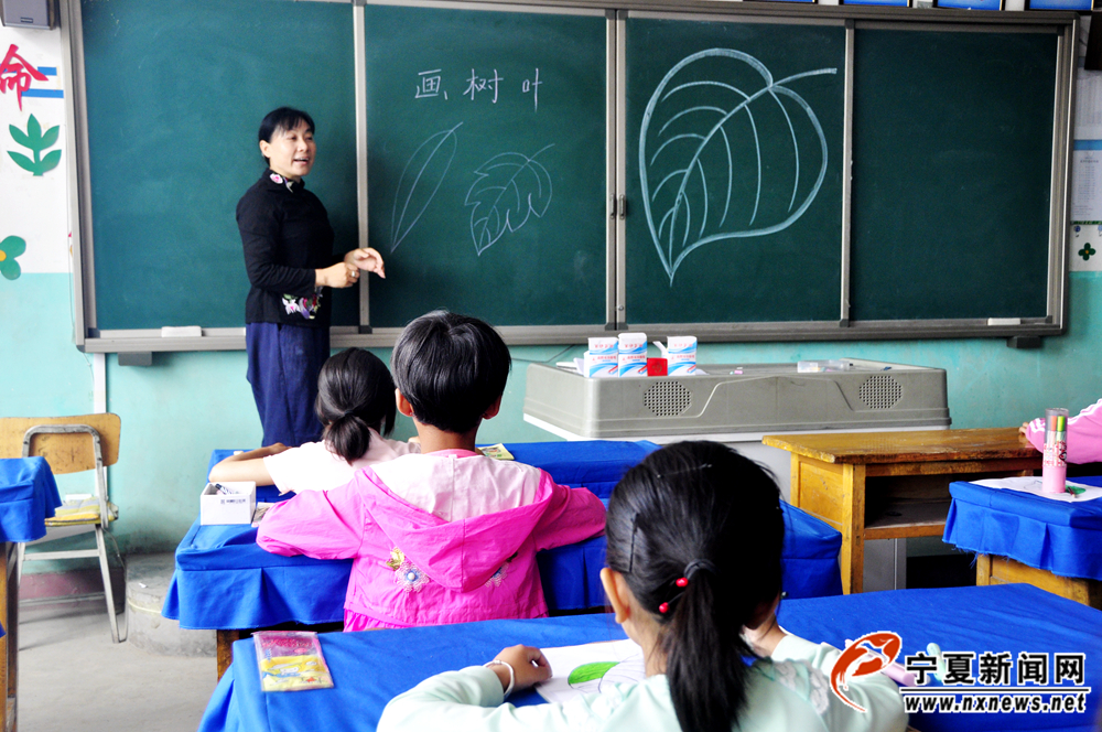 刘秋蓉正在给丁塘镇中心小学的学生上美术课。她讲课语言生动、形象，因此很受学生欢迎。