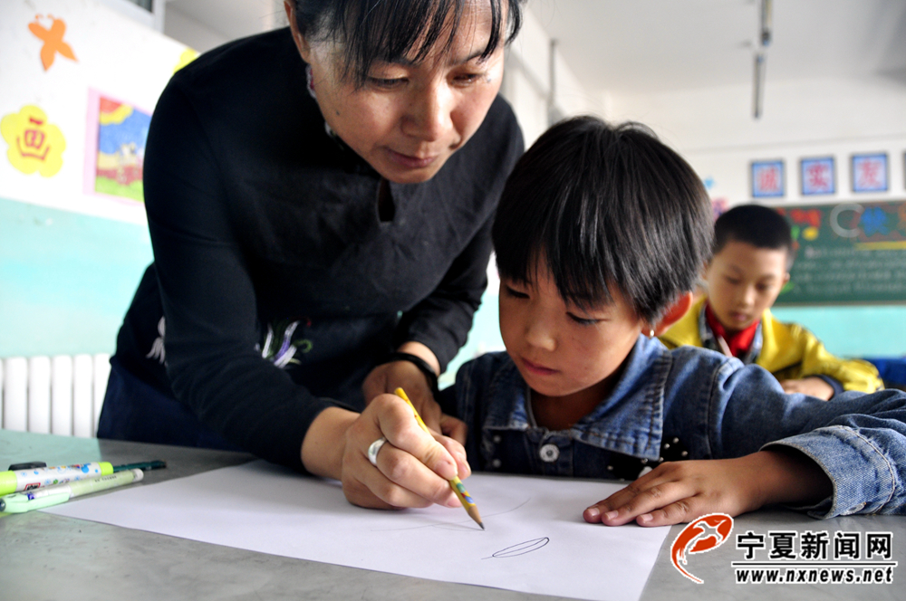 刘秋蓉手把手教孩子画画。