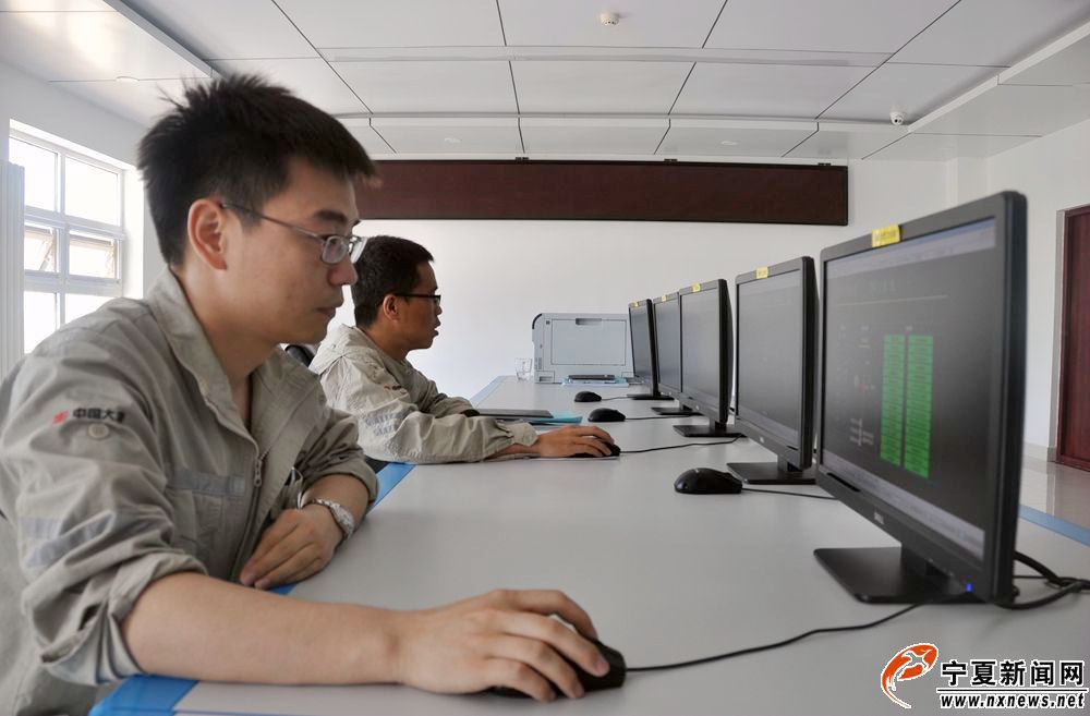 检修员曹东亮与小伙伴认真仔细地看着风电场风机的运行情况。